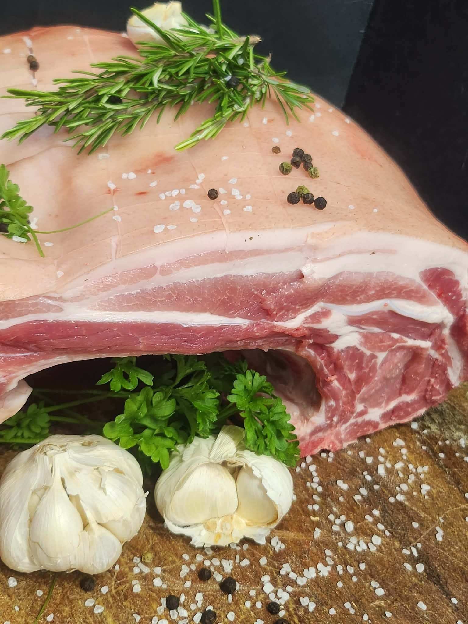 Skin-on rack of pork prepared by hand with garlic and fresh herbs